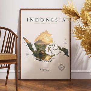 Op de afbeelding: Een ingelijste wandkunstprint met een kaart van Indonesië in een crèmekleurig palet. De kaart bevat een landschapsillustratie van een vulkaan, een traditioneel huis en palmbomen. Tekst bevat INDONESIA, JAKARTA en EST. 1945.