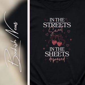 May include: Black t-shirt with the text "IN THE STREETS Sweet, IN THE SHEETS depraved" in white and pink lettering. The design includes cherry graphics and hearts. The shirt also features the Instagram handle @wickedfootnote.
