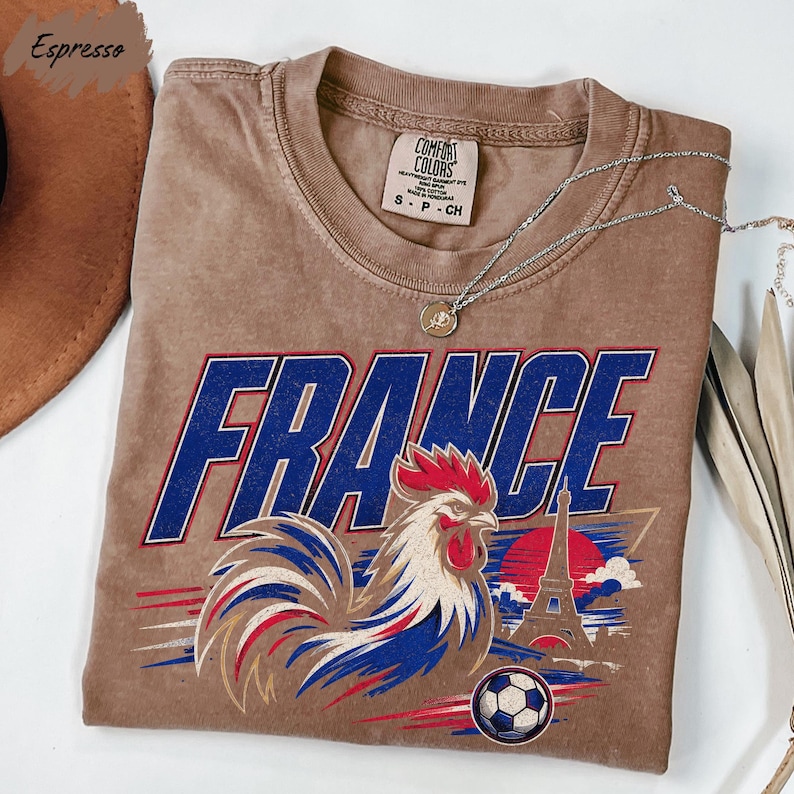 a brown t-shirt with a graphic design of a rooster and a soccer ball, along with the word "FRANCE" written on it.