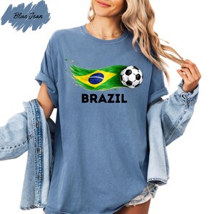 A woman wearing a blue t-shirt with a graphic of a soccer ball and the word "BRAZIL" printed on it, along with a Brazilian flag design.