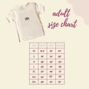 a white t-shirt with a size chart below it, providing measurements for different sizes.