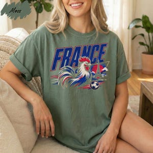 A woman wearing a green t-shirt with a graphic of a rooster and the word "FRANCE" printed on it.