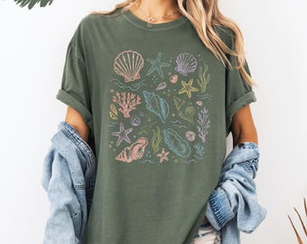 Camiseta playera con conchas marinas, camiseta veraniega costera, camiseta con estampado de conchas en tonos pastel, camiseta con estética oceánica, linda camiseta para vacaciones en la playa.
