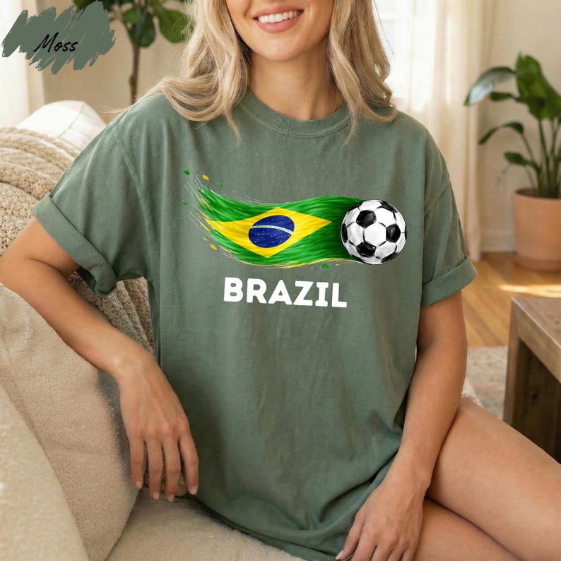 A woman wearing a green t-shirt with the word "BRAZIL" printed on it, along with a graphic of a soccer ball and the Brazilian flag.