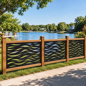 May include: A fence featuring three rectangular panels with a black metal insert displaying a repeating horizontal wave pattern, framed by vertical and horizontal light brown wooden posts and rails, positioned along a grassy area near a lake.