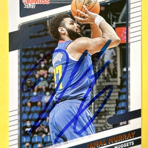 May include: A basketball trading card featuring Jamal Murray of the Denver Nuggets. The card has a white border with the Donruss logo and the text "21-22". Murray is shown in a blue jersey, holding a basketball.