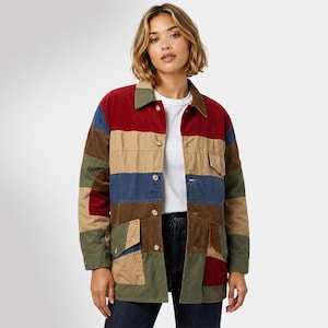 Puede incluir: Una chaqueta de manga larga con botones y diseño de bloques de color con paneles horizontales en tonos burdeos, beige, verde oliva y azul marino. La chaqueta incluye un cuello clásico, dos bolsillos delanteros con solapa y una camiseta blanca.