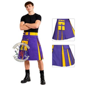 Op de afbeelding: Een persoon draagt een paarse kilt met gele accenten en een gele riem. De kilt heeft een zak en een decoratief embleem. De kilt wordt gecombineerd met een zwart t-shirt en zwarte laarzen. De kilt is van Nice Kilts Apparel & Accessories.