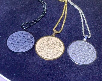May include: Three circular pendants on matching ball chains in black, gold, and silver tones. Each pendant features intricate Arabic calligraphy engraved on the surface, with the black pendant having a dark finish, the gold a metallic finish, and the silver a polished reflective finish.