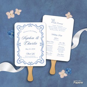 May include: Two white wedding program fans with wooden handles featuring blue text and ornate borders. The front displays "Welcome to Our Wedding," "Sophia & Charlie," "May 10, 2030," and "Thank You." The back lists "The Ceremony" and "Wedding Party."