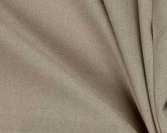 May include: Close-up of a tan fabric with a subtle woven texture. The fabric is draped, creating soft folds and shadows. The neutral color and texture suggest it could be used for clothing or home decor.