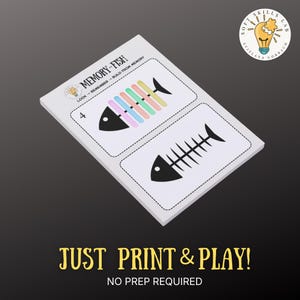 May include: A white card with two fish illustrations, one with colorful bars and the other a black fish skeleton. The text "MEMORY-FISH" and "JUST PRINT & PLAY!" are visible. The card is designed for memory building.