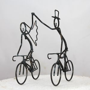 Bride and Groom Holding Hands on Bikes Cake Toppers