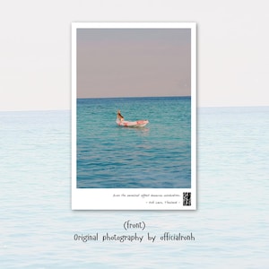 May include: A photograph of a person floating on a pink inflatable raft in turquoise water. The sky is a pale blue. The image includes text that reads "Even the smallest effort deserves celebration - Koh Lam, Thailand - (front) Original photography by officialronh."