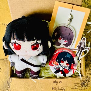 May include: A plush doll with black hair and red eyes, wearing a white outfit with burgundy accents, sits in a box with a keychain, a button, and a sticker. The button has the text "LIMBUS COMPANY".