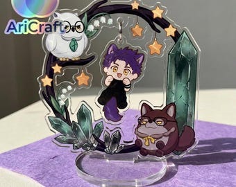 May include: A clear acrylic standee featuring a purple-haired character with cat ears, a white owl with glasses, and a brown creature with glasses. The design includes dark tree branches, green crystals, lily of the valley, and stars with AriCraft text.