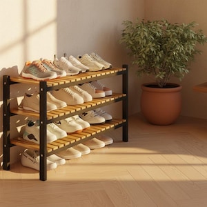 May include: A three-tiered shoe rack with black metal supports and natural wood shelves. The rack is filled with various pairs of sneakers and shoes in neutral colors. A potted plant sits nearby.