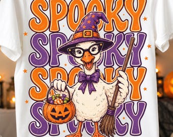 May include: A white t-shirt featuring a graphic of a goose wearing a purple witch hat, black glasses, and a purple bow tie. The goose holds a jack-o'-lantern candy bucket and a broom. The word SPOOKY is repeated in orange and purple text.