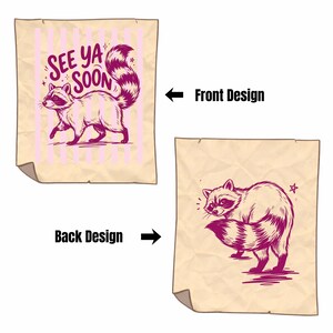 May include: Two-sided design featuring a raccoon illustration. The front design has a raccoon with the text "See Ya Soon" on a pink striped background. The back design shows a raccoon with a star.