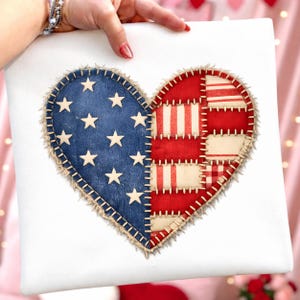 Könnte beinhalten: Ein weißes quadratisches Kissen mit einem Herzdesign. Das Herz ist in zwei Bereiche unterteilt: einen mit blauem Hintergrund und weißen Sternen und den anderen mit rot-weiß gestreiften und karierten Mustern. Das Herz hat einen beigefarbenen, genähten Rand.