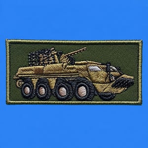 以下が含まれることがあります： オリーブグリーンの背景に、タンカラーの8輪装甲軍用車両が刺繍された長方形のワッペン。車両には大砲を備えた砲塔、黒いタイヤがあり、その構造を定義する詳細なステッチが施されています。