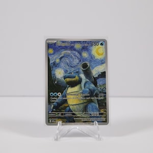 May include: A Pokémon trading card featuring Blastoise, set against a backdrop inspired by Van Gogh's "Starry Night." The card showcases a blue and yellow Blastoise with two cannons on its back. The card is displayed on a clear plastic stand.