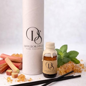 May include: A home fragrance set featuring a cylindrical container and a small glass bottle with a cream-colored wax seal. The set includes reed diffuser sticks, rhubarb stalks, and sugar crystals. The brand name "DIFFUZOR.STUDIO" is visible.