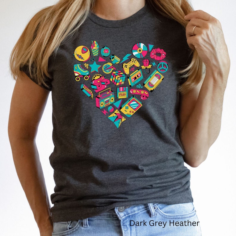 May include: A dark grey heather t-shirt with a heart-shaped design made up of various 80s and 90s icons, including roller skates, cassette tapes, video game controllers, and a boombox. The text "Dark Grey Heather" is printed below the image.