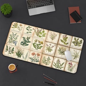May include: A rectangular mousepad featuring botanical illustrations of various plants and flowers on a cream-colored background. The mousepad has a black border and is surrounded by a laptop, a notebook, a pen, and a cup of coffee.