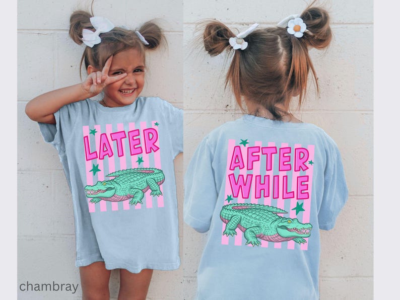 Puede incluir: Camiseta azul claro con un dise&ntilde;o de cocodrilo verde y rosa. La parte delantera de la camiseta dice "LATER" y la trasera "AFTER WHILE". Corte holgado, ideal para ni&ntilde;os.