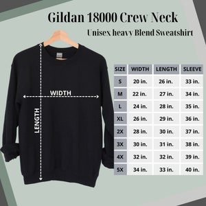 May include: Black Gildan 18000 Crew Neck Unisex heavy Blend Sweatshirt hanging on a wooden hanger. The image includes a size chart with measurements in inches for width, length, and sleeve length, ranging from size S to 5X.
