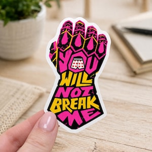 May include: A die-cut sticker featuring a stylized gauntlet graphic in vibrant pink and yellow. The design includes the text "YOU WILL NOT BREAK ME" in bold, blocky lettering, with a small illustration of white boxer shorts with red hearts.