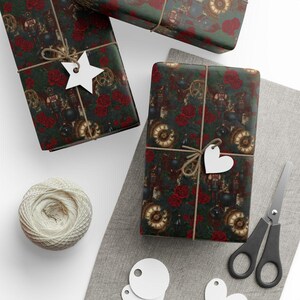 May include: Wrapped gifts with a dark green background featuring a repeating pattern of vintage clocks, gears, and red roses. Each package is tied with twine and a white tag. A ball of twine, scissors, and blank tags are also visible.