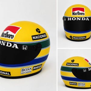 May include: A yellow racing helmet featuring a black visor and horizontal green and blue stripes. The helmet displays the text Marlboro, Honda, Nacional, Boss, and Rheos, along with the Honda logo, replicating a classic Formula 1 design.