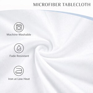 May include: Close-up of a white microfiber tablecloth, with the text "MICROFIBER TABLECLOTH". The image highlights the fabric's texture and features icons and text indicating it's machine washable, fade-resistant, and ironable at low heat.