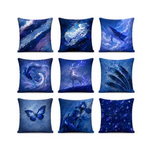 Peut inclure: Un ensemble de neuf coussins carrés présentant divers motifs dans les tons bleus, incluant une baleine, un cerf aux bois lumineux, un papillon, des coups de pinceau abstraits, des motifs floraux et des éléments cosmiques en bleu marine et azur.