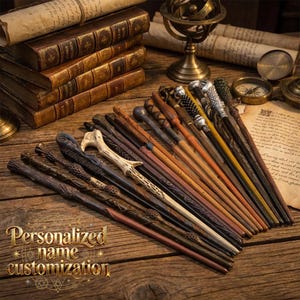 May include: A collection of intricately designed wands in various colors, including brown, black, and tan, arranged on a wooden surface. The wands have unique handle designs. The image also includes old books, scrolls, and a globe. Text on the image reads "Personalized name customization."