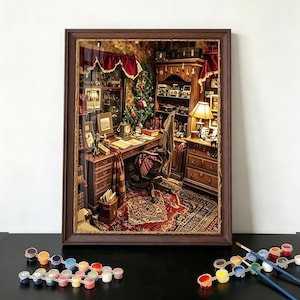 Puede incluir: Un diorama en miniatura enmarcado de un estudio con escritorio, silla y estantería. La escena incluye un árbol de Navidad, una alfombra estampada y una lámpara. Botes de pintura y pinceles en primer plano.