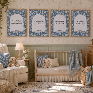May include: A cozy nursery scene with four framed prints featuring inspirational quotes on a blue floral background. The room includes a crib, armchair, and a woven basket, all in soft, neutral tones. A lamp and stuffed animals add to the inviting atmosphere.