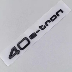 May include: Black 40 e-tron emblem on a white rectangular sticker. The emblem features a glossy finish and is designed for automotive applications. The text is in a sans-serif font.
