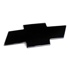 May include: A glossy black Chevrolet emblem with a silver border. The emblem is a stylized bow tie shape, commonly used as a car badge. The emblem is set against a white background.