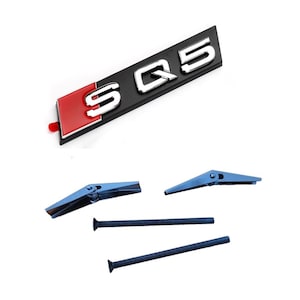 May include: A black and silver SQ5 emblem with a red accent, along with blue metal fasteners and screws. The emblem features the letters "SQ5" in silver against a black background.