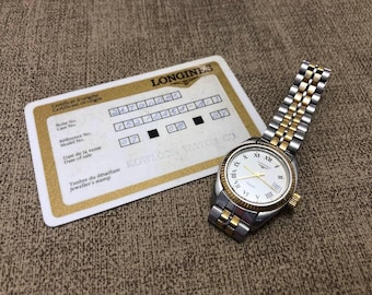 Reloj de cuarzo Longines para mujer, de 25 mm, con detalles en oro y plata, esfera blanca y tarjeta descatalogado.