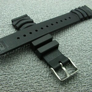 May include: A black rubber watch strap with a stainless steel buckle. The strap is marked "SEIKO Z-20" and features multiple holes for adjustment. The strap is approximately 20 cm long.