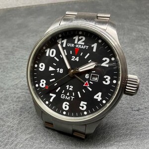 May include: A stainless steel UHR-KRAFT wristwatch with a black dial, white Arabic numerals, and a date window at the three o'clock position. The watch features a GMT function with a red-tipped hand, luminous hands, and a brushed metal link bracelet.