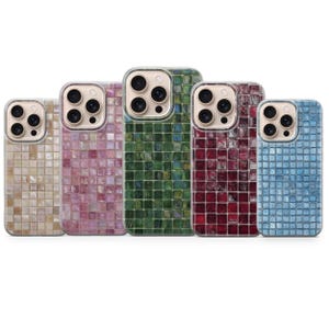 Pode incluir: Cinco capas de telemóvel com um design de mosaico. As capas são em várias cores, incluindo bege, rosa, verde, bordô e azul. Cada capa tem um recorte para a câmara e uma borda transparente.
