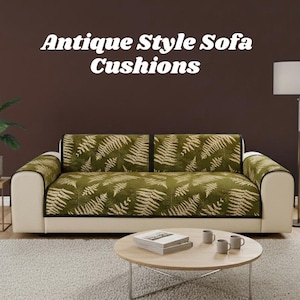 May include: A cream sofa with green fern-patterned cushions and black trim. The sofa has cream armrests and is against a brown wall. A round wooden coffee table with books and mugs sits in front of the sofa. Text on the image reads "Antique Style Sofa Cushions."