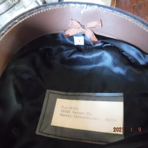 May include: A black hat with a brown leather band and a white label with the text "P.J. Skill 12021 Verans Ct. Rancho Bernardo, Cal. 92124" inside.