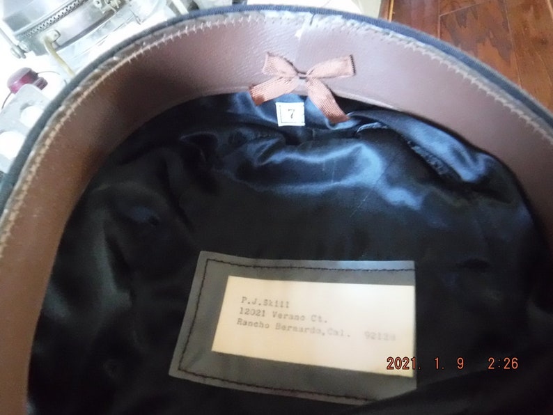 May include: A black hat with a brown leather band and a white label with the text "P.J. Skill 12021 Verans Ct. Rancho Bernardo, Cal. 92124" inside.