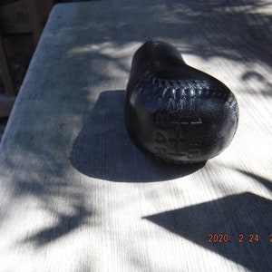 May include: Black leather gear shift knob with the numbers 1, 2, 3, 4, 5, and R embossed on the top.